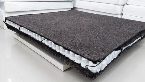 Pocket spring mattress with the felt insulating layer visible over the individually wrapped coils