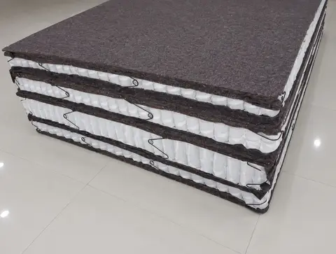 Stacked cross-section of pocket spring mattress units showing the felt layer between coil rows