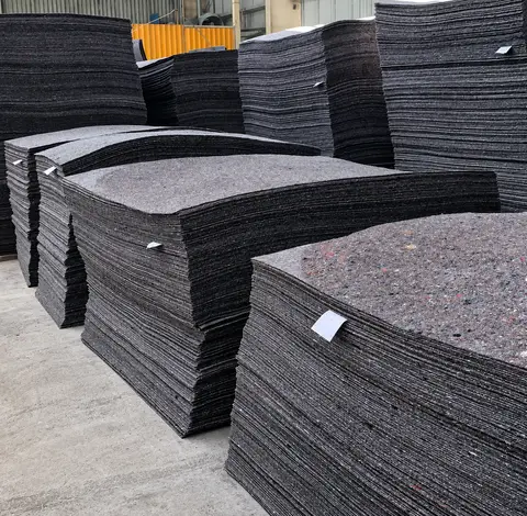 Stacks of non-woven felt sheets on pallets in the factory